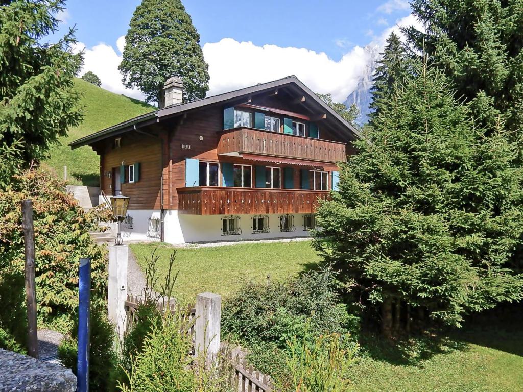 ein großes Holzhaus mit einem Zaun und Bäumen in der Unterkunft Apartment Chalet Bienli-2 by Interhome in Grindelwald