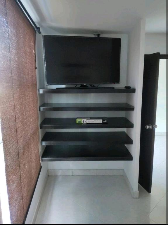 een tv op een plank in een kamer bij Apartaestudio en arriendo in Neiva