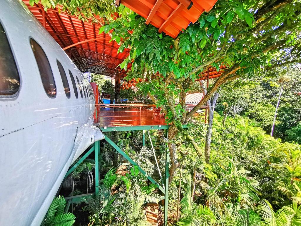 un aeroplano bianco parcheggiato accanto a un albero di Hotel Costa Verde a Manuel Antonio