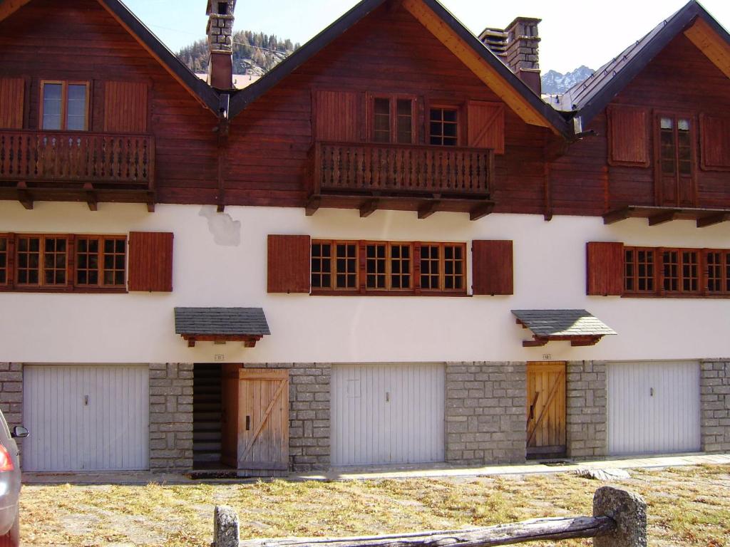 ein großes Holzgebäude mit Türen und Fenstern in der Unterkunft Holiday Home Le Tre Cime by Interhome 