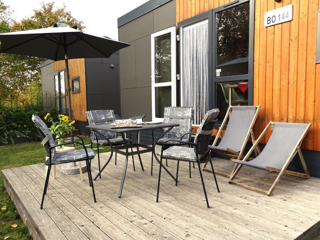 a table and chairs with an umbrella on a deck at Holiday Home Neschtle by Interhome in Wemding