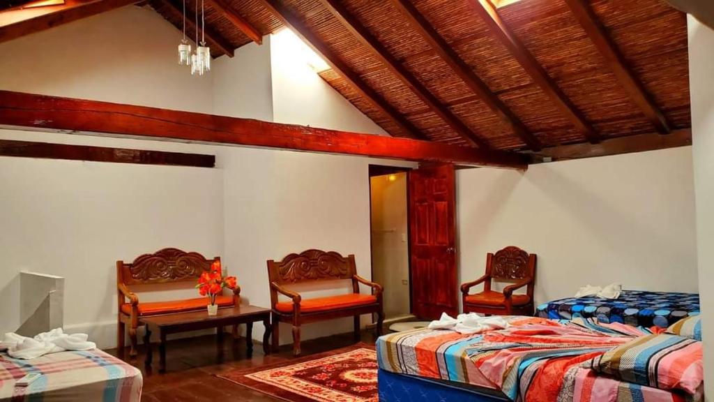 1 Schlafzimmer mit 2 Betten, 2 Stühlen und einem Tisch in der Unterkunft Hotel Camaleon Granada in Granada