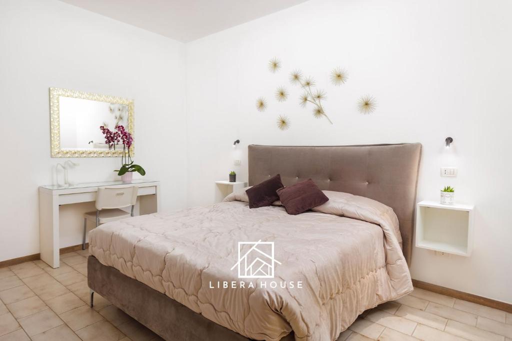 LIBERA HOUSE - Sweet Apartments في سان سالفو: غرفة نوم مع سرير ومكتب وسرير sidx sidx