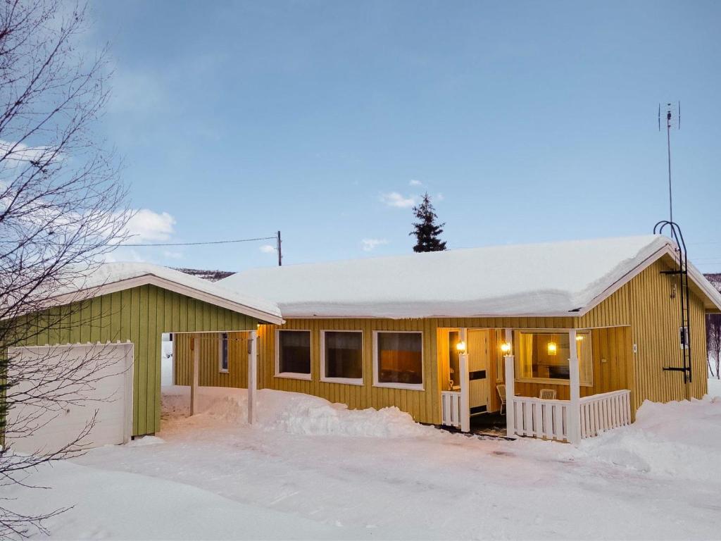 a yellow house with snow on the roof at Holiday Home Saajola by Interhome in Leppäjärvi