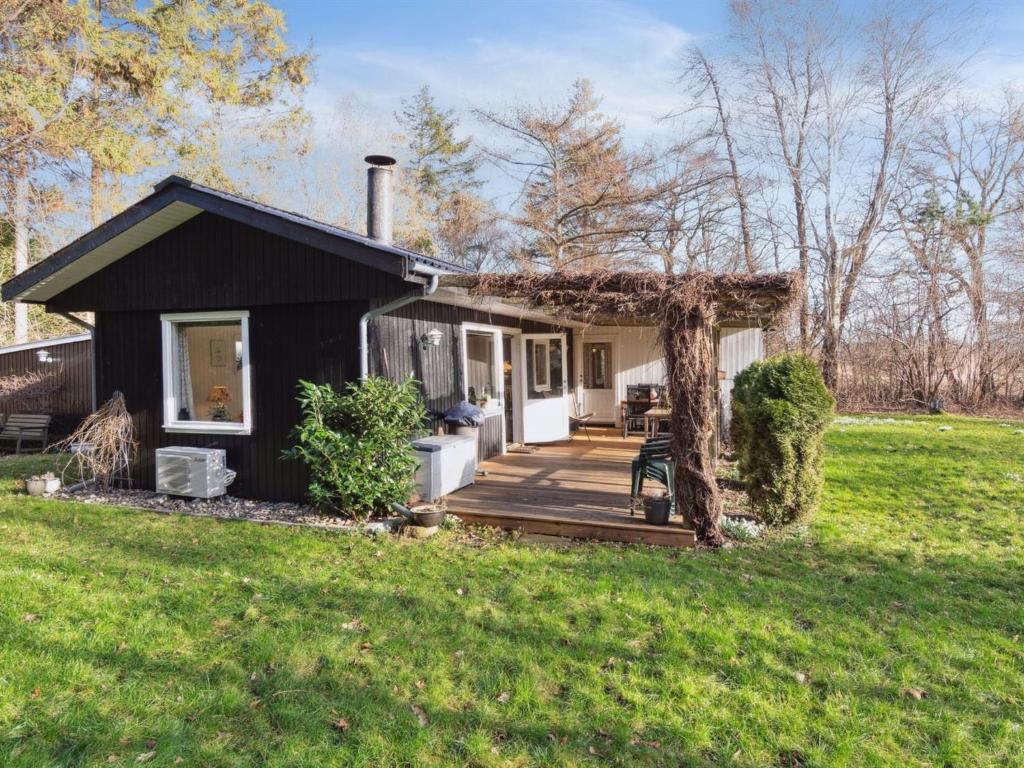 a black house with a porch and a yard at Holiday Home Oona - 1-8km from the sea in Sealand by Interhome in Vig