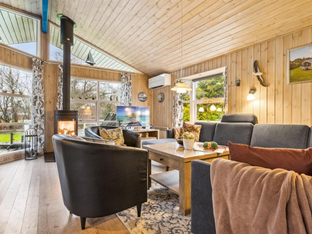 uma sala de estar com uma mesa e cadeiras e uma lareira em Holiday Home Alruna - all inclusive - 350m from the sea by Interhome em Brøndstrup