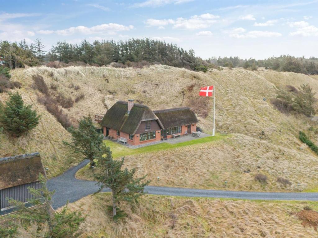una casa su una collina con una bandiera canadese di Holiday Home Damiana - 600m from the sea in NW Jutland by Interhome a Blokhus