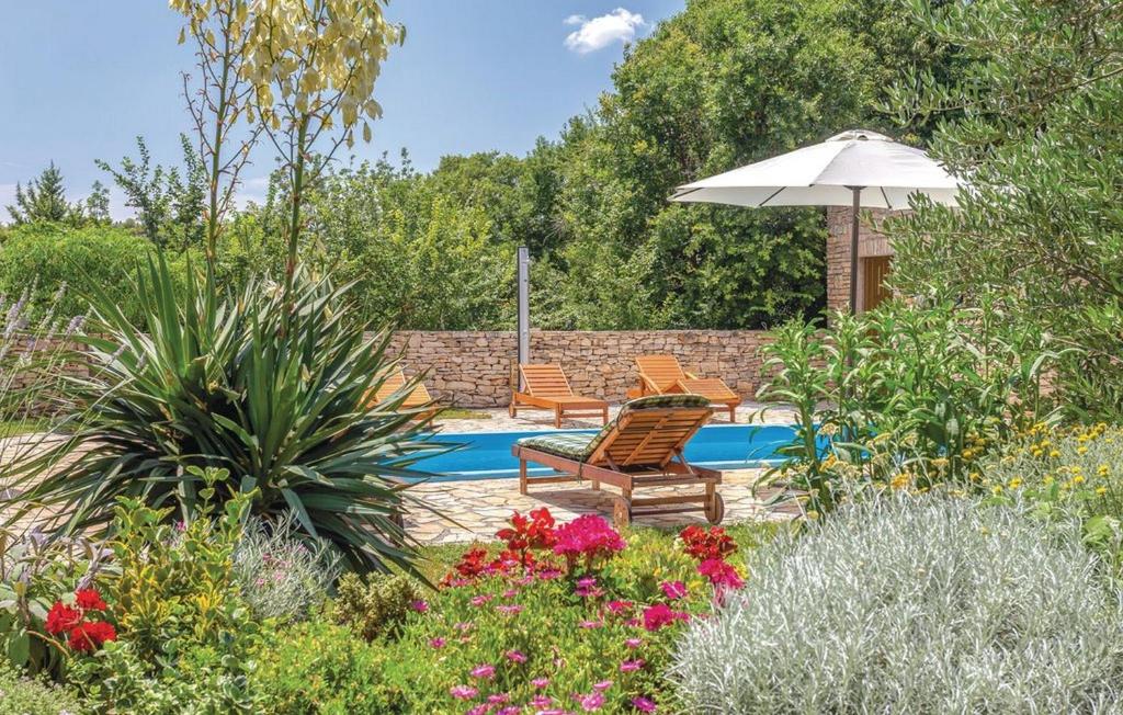 a patio with two chairs and an umbrella in a garden at House Soul in Oklaj