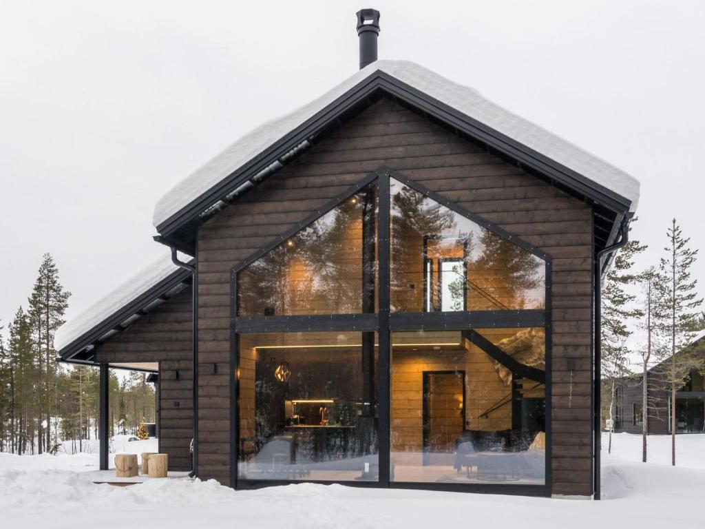 a house with large glass windows in the snow at Holiday Home Levin kuiskaus by Interhome in Sirkka