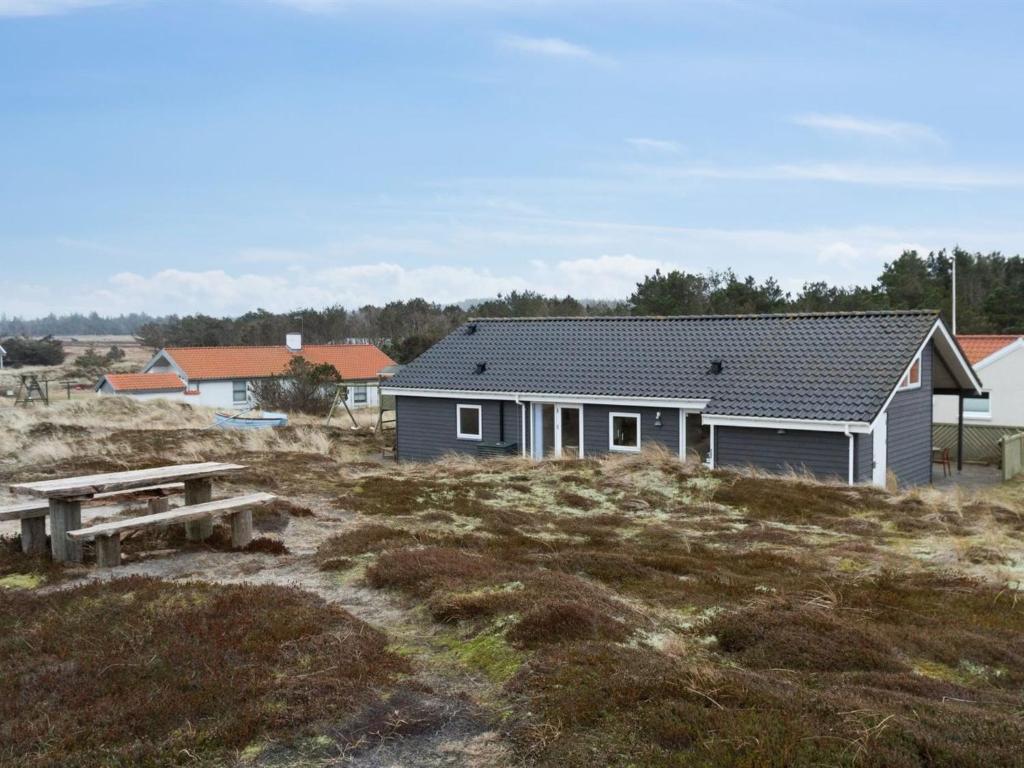 een huis op een heuvel met een picknicktafel bij Holiday Home Ani - 600m from the sea in NW Jutland by Interhome in Torsted