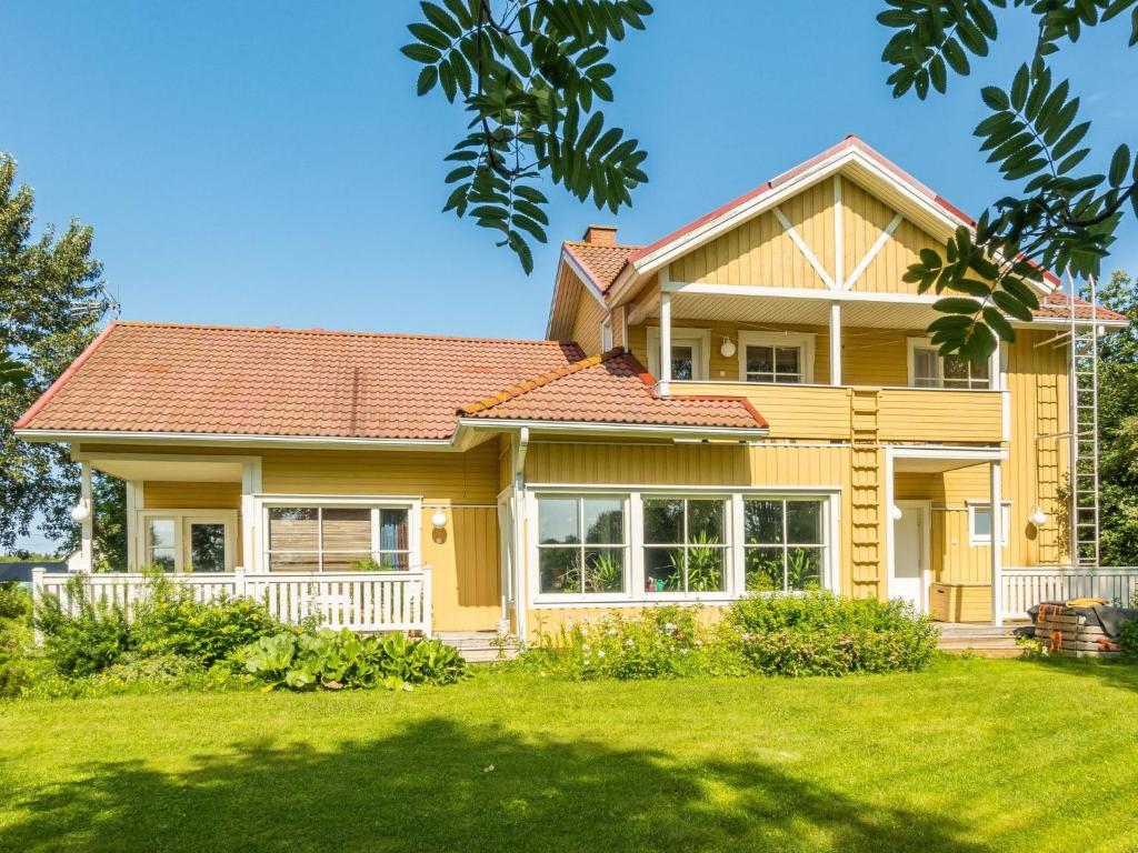 una casa amarilla con techo rojo en Holiday Home Grand villa kemijoki by Interhome, en Kupari