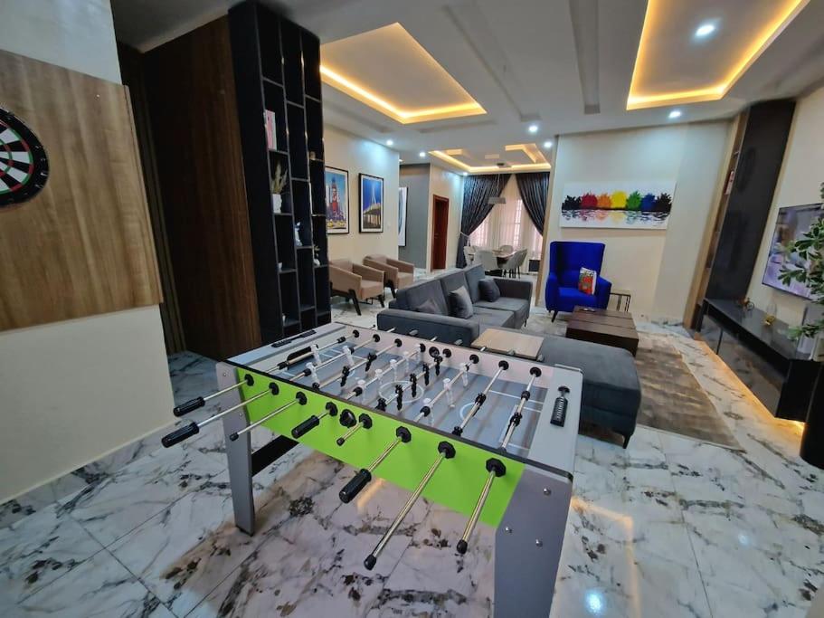 a living room with a ping pong table at Plushly-Furnished Three-Bedroom Apartment in Wuye in Abuja
