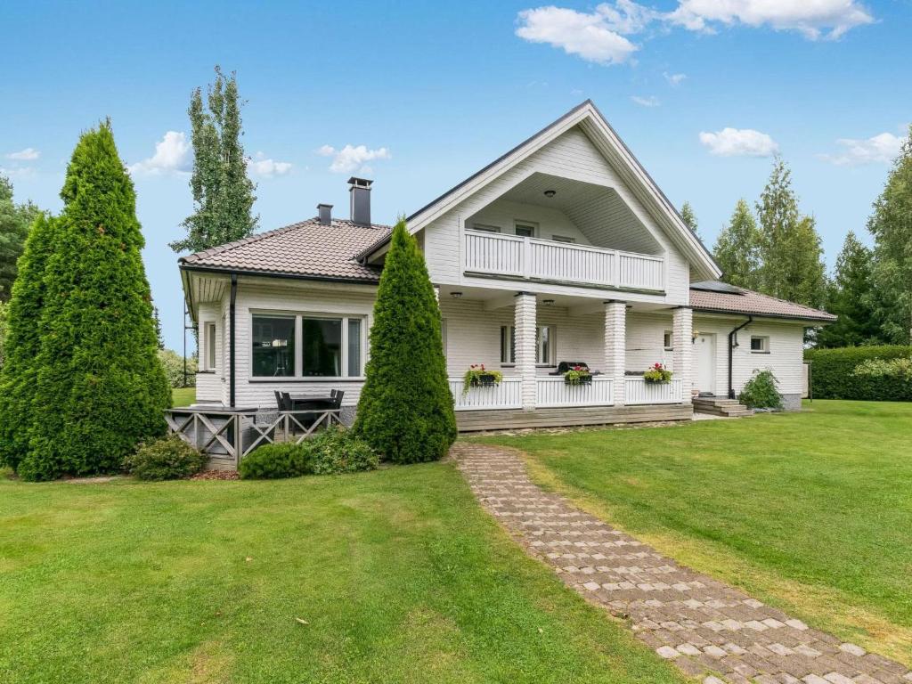 a white house with a lawn and trees at Holiday Home Villa jokiranta by Interhome in Eurajoki