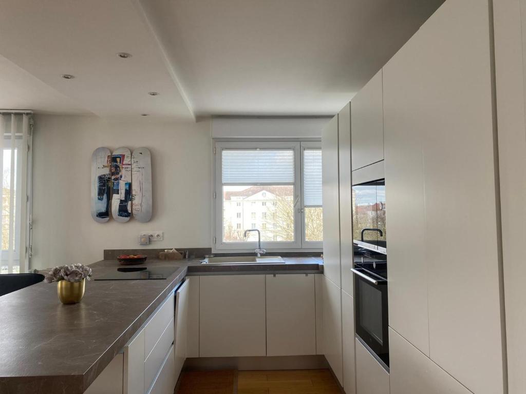 een witte keuken met een wastafel en een raam bij Mickey House 6 pers 10 Min Disney & 30Min Paris in Bussy-Saint-Georges
