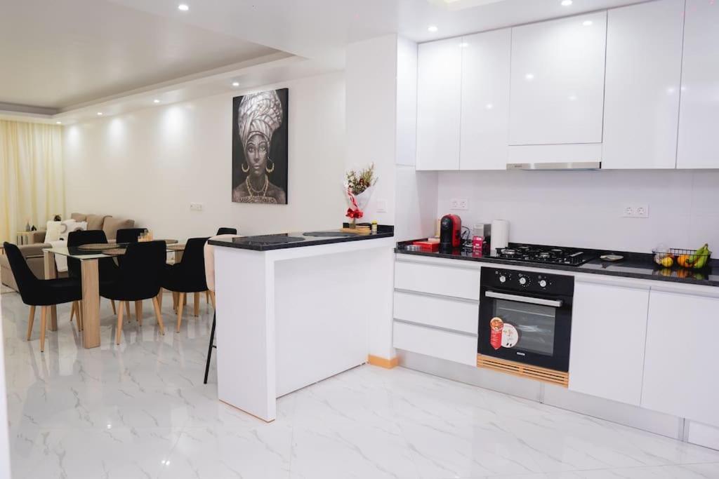 a kitchen with white cabinets and a dining room at Saw Paradise in Praia T2 in Praia