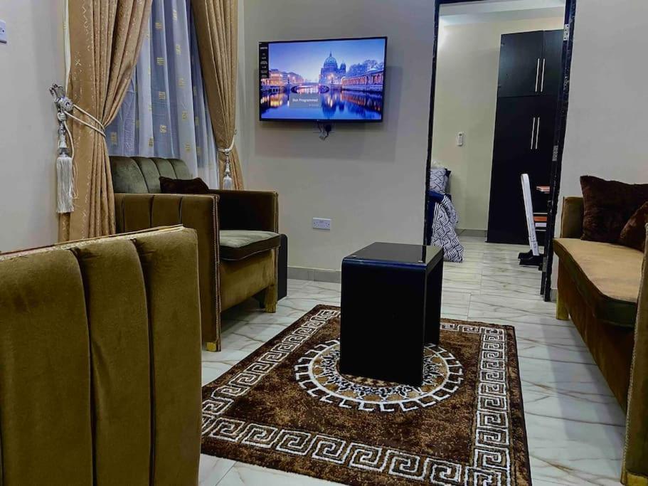 a living room with a television on the wall at Enugu Airbnb / shortlet Serviced Apartment in Enugu