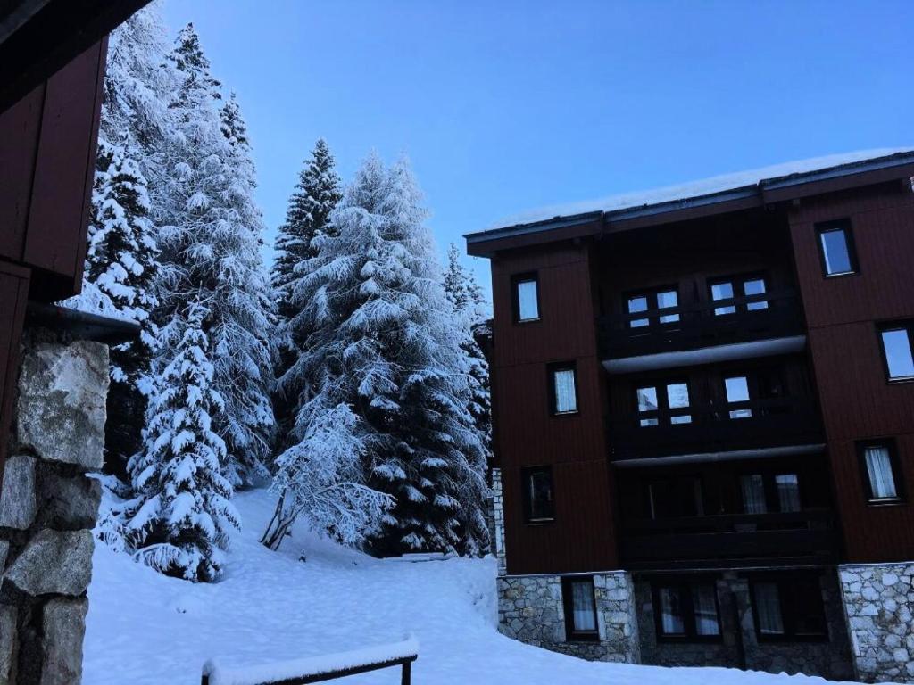 a snow covered yard next to a building and trees at Résidence Plagne Lauze - maeva Home - Studio 4 personnes - Confort MAE-4344 in Mâcot La Plagne