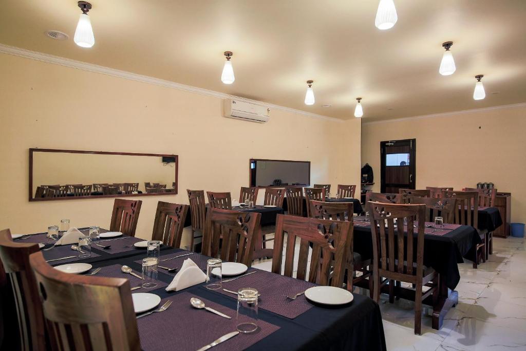 un comedor con mesas, sillas y luces en Collection O Hotel Sincro en Madgaon