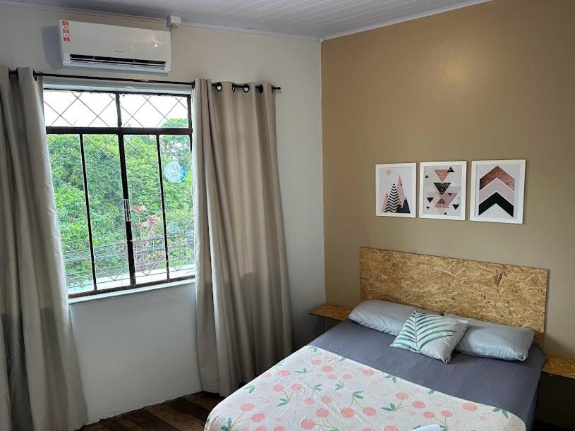 1 dormitorio con cama y ventana en Quarto Econômico com Ar Cond. e Smart Tv Netflix, en Itajaí