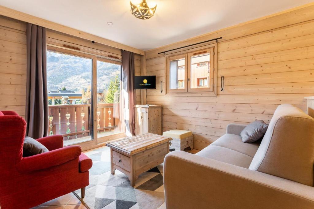 un salon avec un canapé, des chaises et une fenêtre dans l'établissement Résidence Les Fermes de Méribel - maeva Home - Appartement 3 pièces 6 personnes - Sélection MAE-7404, à Les Allues