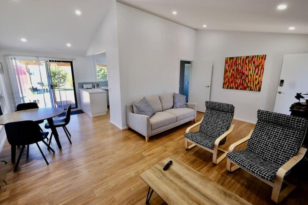 a living room with a couch and a table and chairs at Beach House with Sea Views and a Large Backyard in Devonport