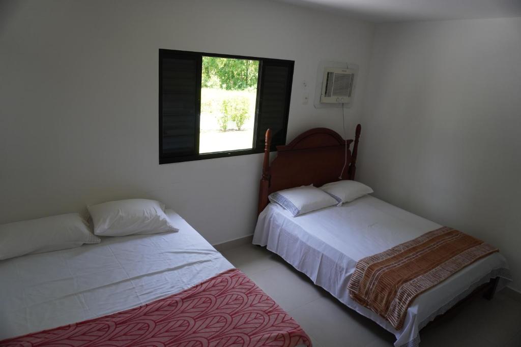 2 Betten in einem Zimmer mit Fenster in der Unterkunft Casa do Sol na Reserva do Paiva in Cabo de Santo Agostinho