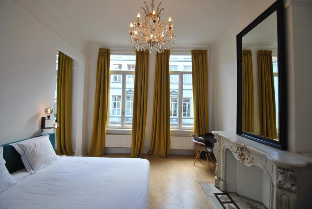 1 dormitorio con cama, espejo y lámpara de araña en Upstairs, en Amberes