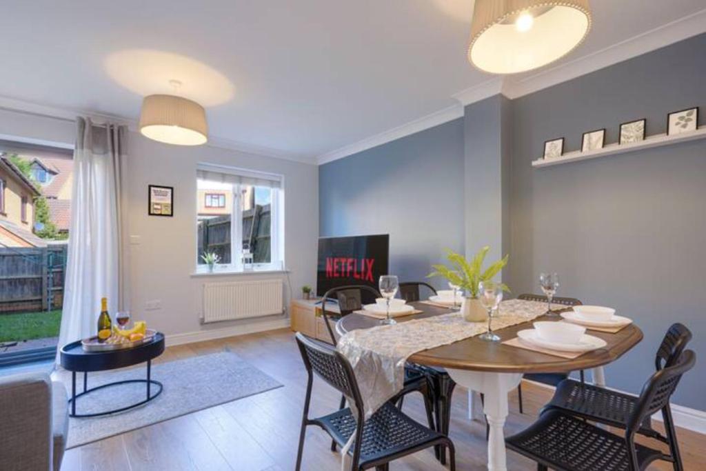 a living room with a dining room table and chairs at Forthill House - Close to City Centre - Free Parking, Super-Fast Wifi and Smart TV with Netflix by Yoko Property in Milton Keynes