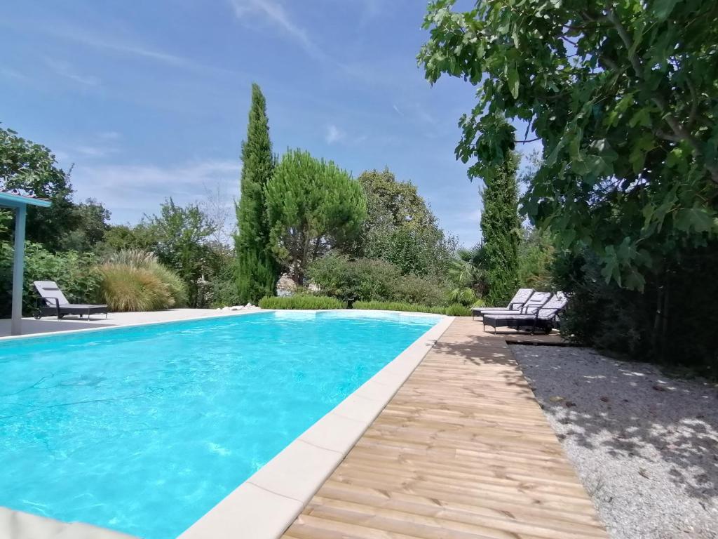 una piscina en un jardín con 2 sillas en Domaine de la Garenne Ronel en Ronel