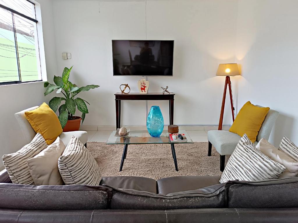 ein Wohnzimmer mit einem Sofa und einem Tisch in der Unterkunft Exclusivo departamento Céntrico con Terraza in Ferreñafe