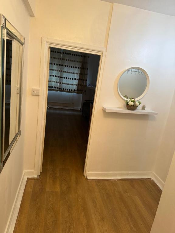 einen Flur, der zu einem Zimmer mit einem Spiegel an der Wand führt in der Unterkunft one bedroom apartment in Tower Bridge road in London