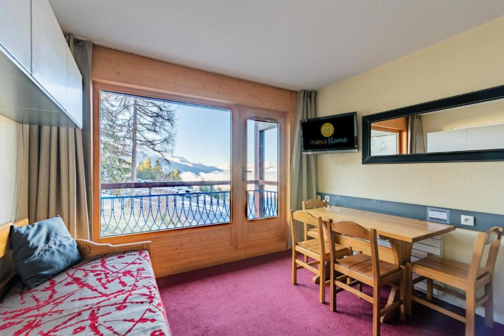 une pièce avec une table, des chaises et une fenêtre dans l'établissement Résidences quartier Charmettoger - maeva Home - Appartement 2 pièces 5 personnes - Sélection MAE-6324, à Arc 1800