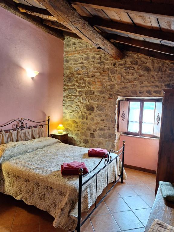 1 dormitorio con cama y pared de ladrillo en Agriturismo Ristoro del Cavaliere, en Piazza al Serchio