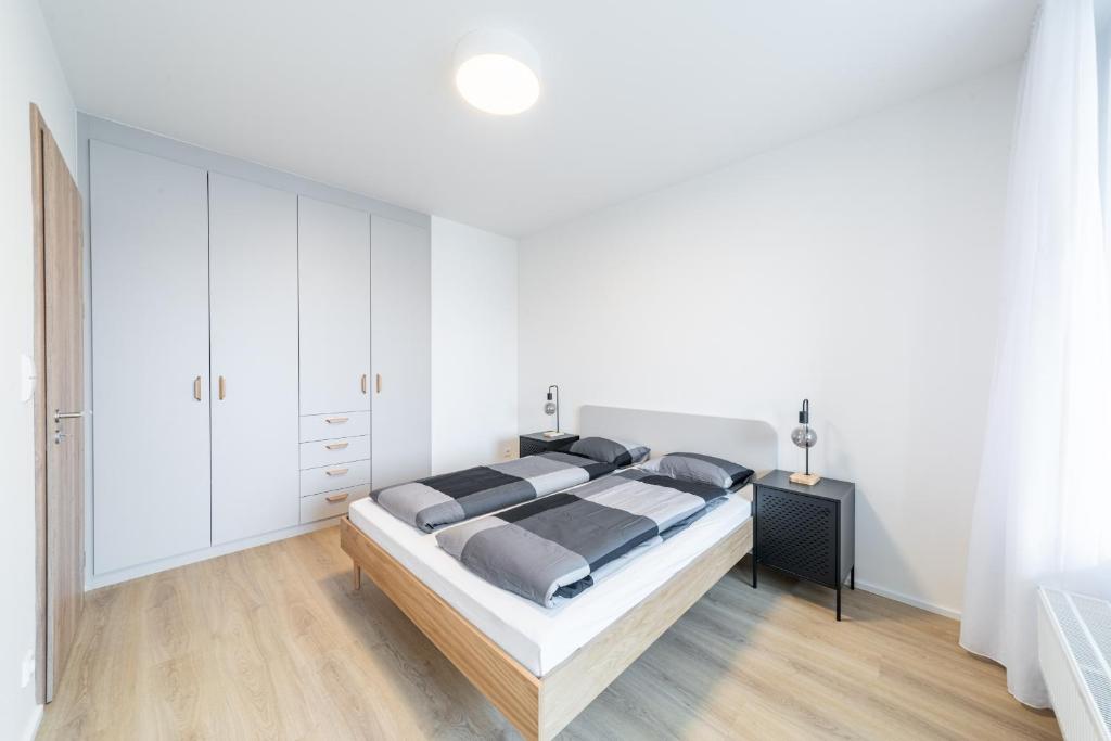a white bedroom with a large bed and white cabinets at Residence Mozaika in Prague