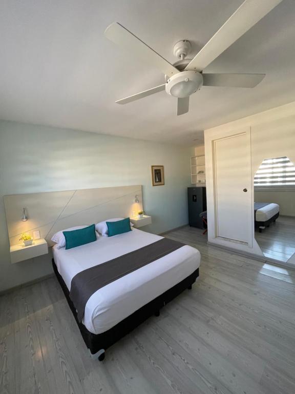 1 dormitorio con 1 cama grande y ventilador de techo en Constanza Lofts Executives en Zapopan Jalisco, en Guadalajara
