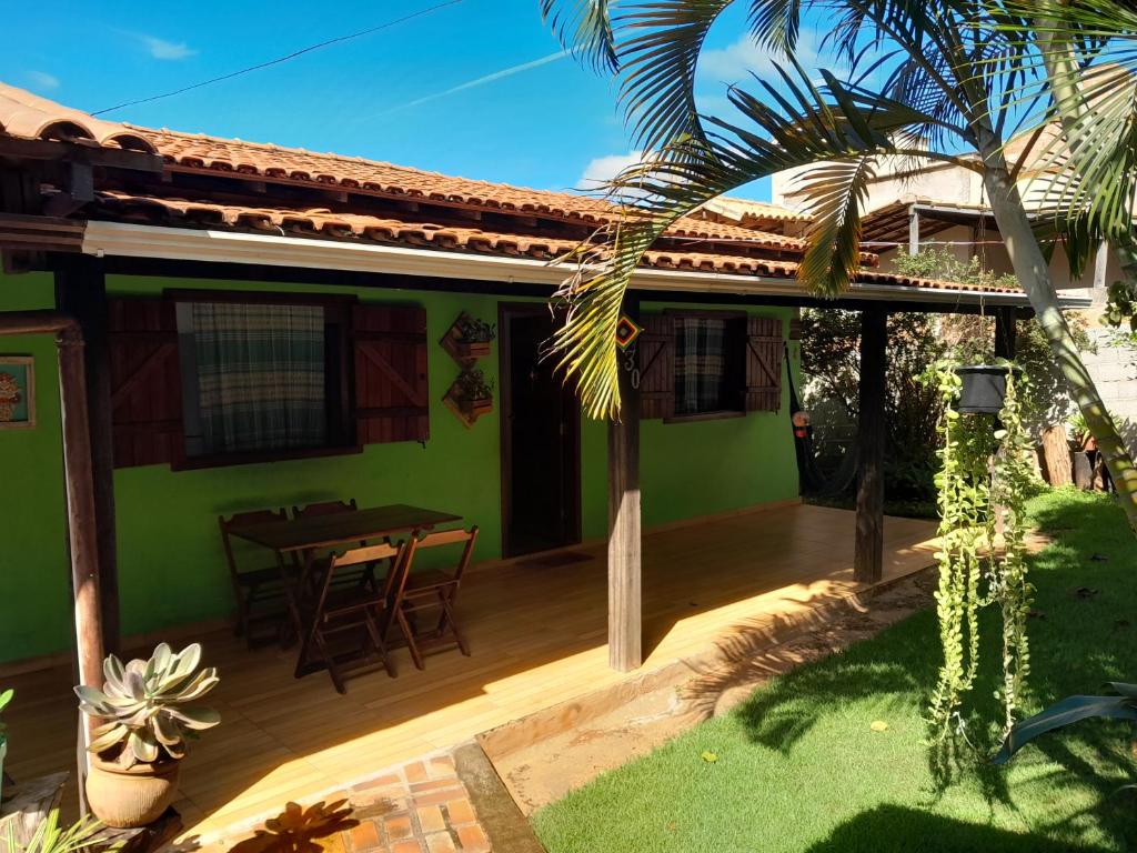 a house with a patio with a table in the yard at Casa das Violetas - Serra do Cipó in Serra do Cipo