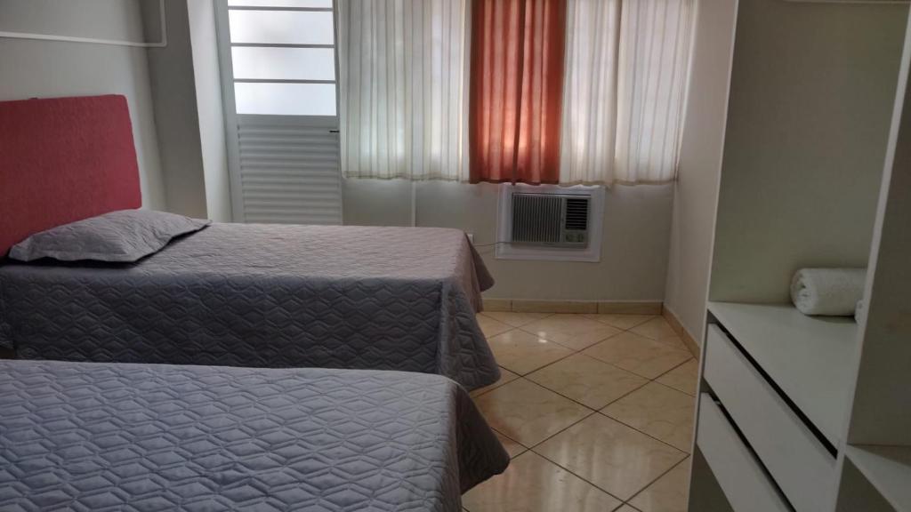 a small bedroom with two beds and a window at Wana casa 2 Requinte e conforto in Sao Jose do Rio Preto