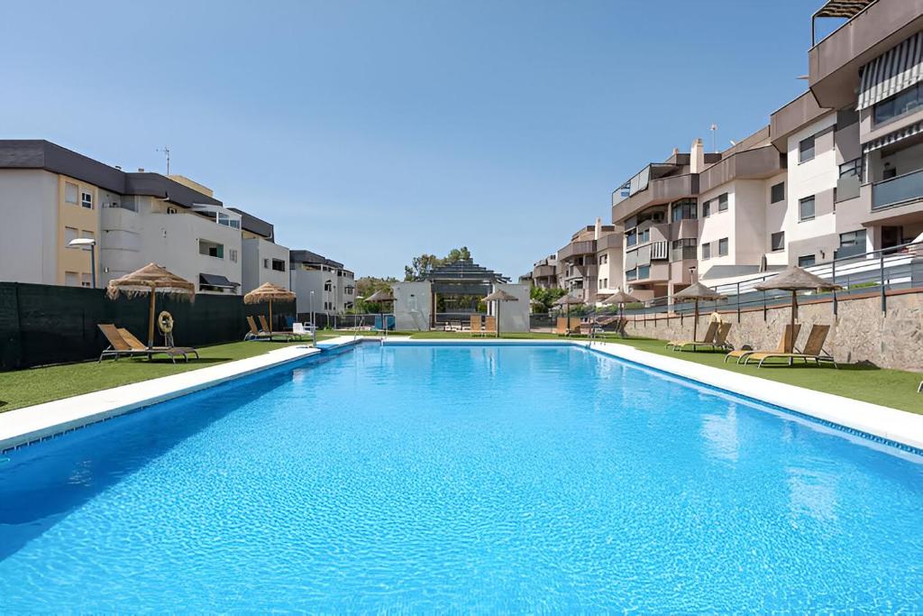 una piscina de agua azul frente a algunos edificios en Ven descansa y conoce Málaga en Málaga