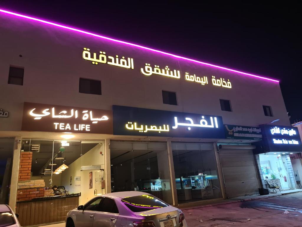 een auto geparkeerd voor een theewinkel 's nachts bij فخامة اليمامة للشقق الفندقية in Riyad