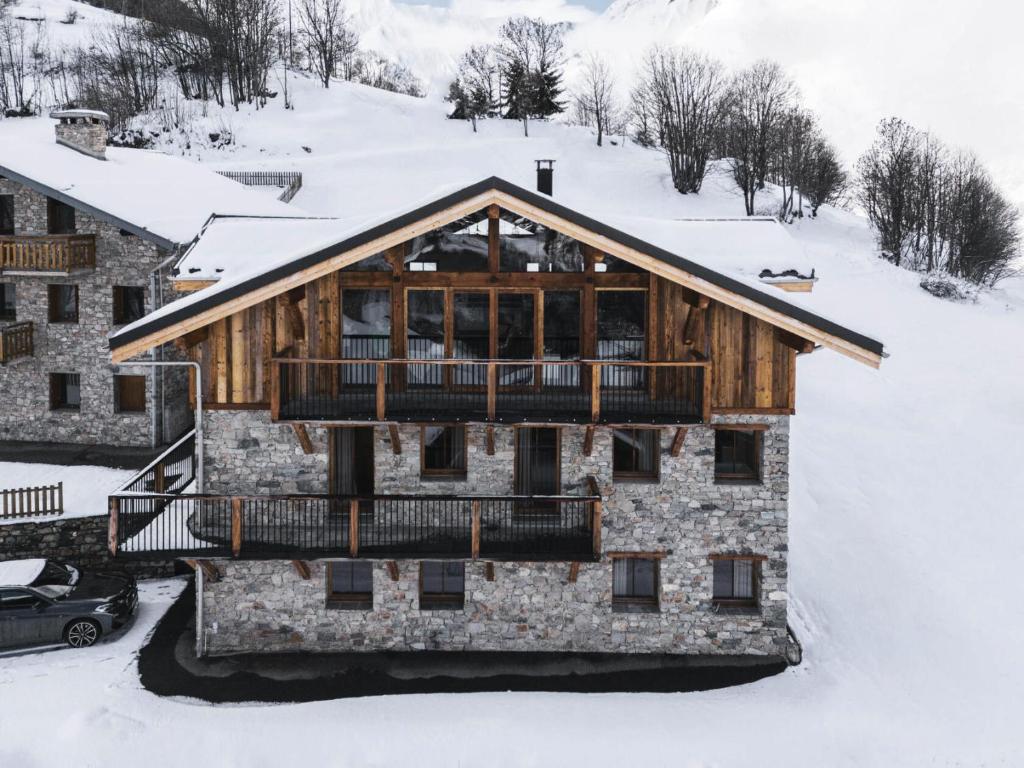 a log cabin in the snow with a balcony at Résidence Le Bercail - Chalets pour 12 Personnes 224 in Saint-Martin-de-Belleville