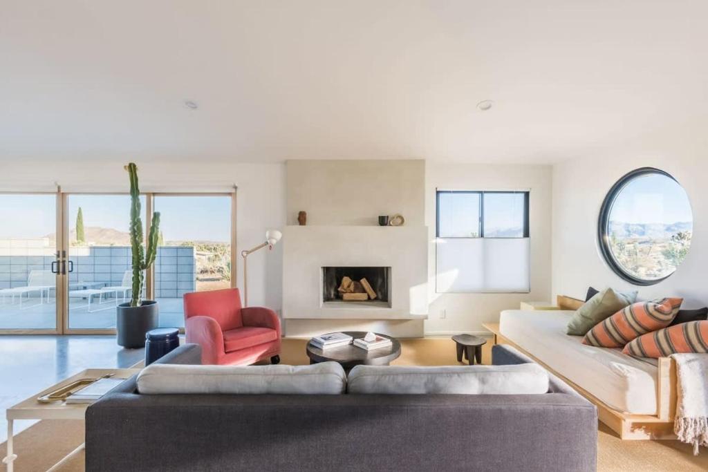uma sala de estar com um sofá e uma lareira em Yucca Hut - Design Forward Oasis Near Joshua Tree em Joshua Tree