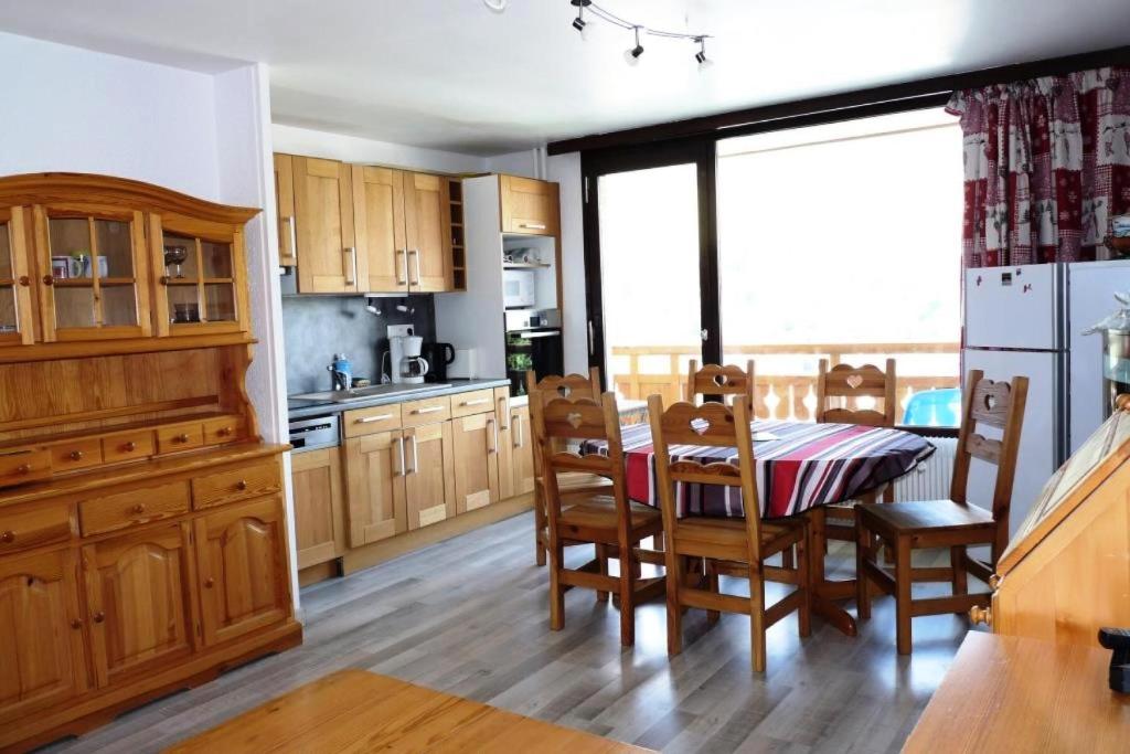 une cuisine avec des armoires en bois et une table et des chaises dans l'établissement Appartement 6 pers. pied des pistes - 2 Pièces 6 Personnes MAE-8812, à Les Deux Alpes