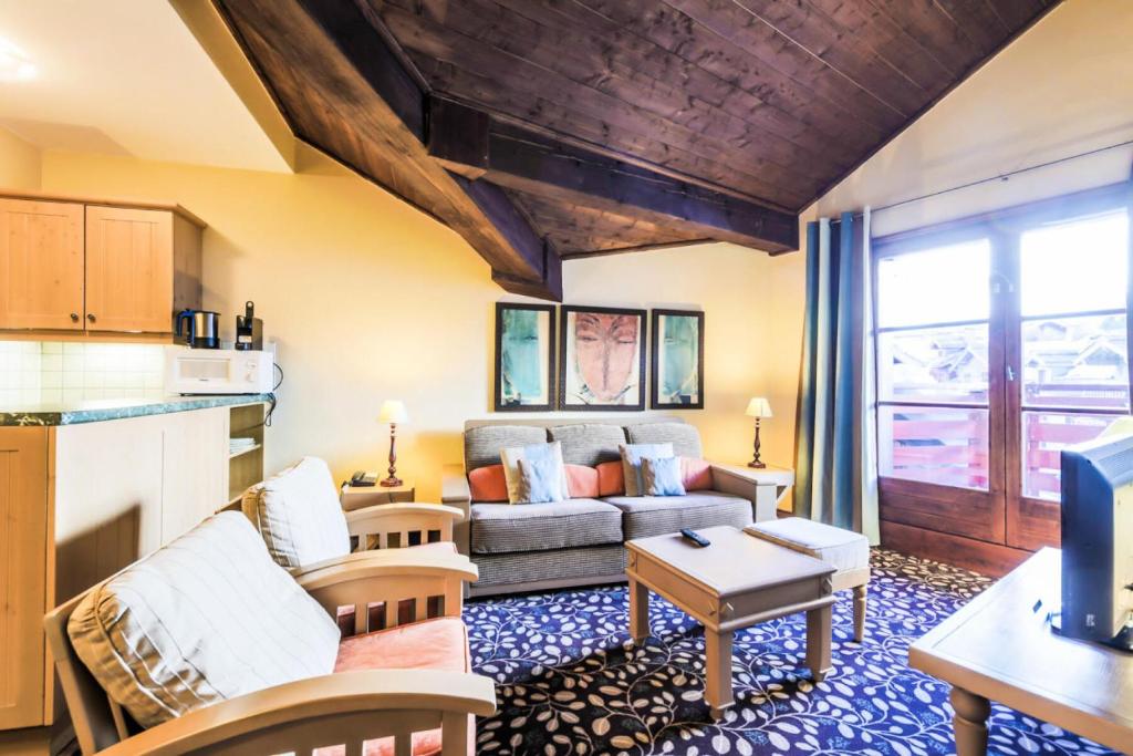 un salon avec un canapé et une table dans l'établissement Résidence Les Arcs 1950 Le Village - maeva Home - Appartement 2 pièces 4 personnes Sélection MAE-3900, à Bourg-Saint-Maurice