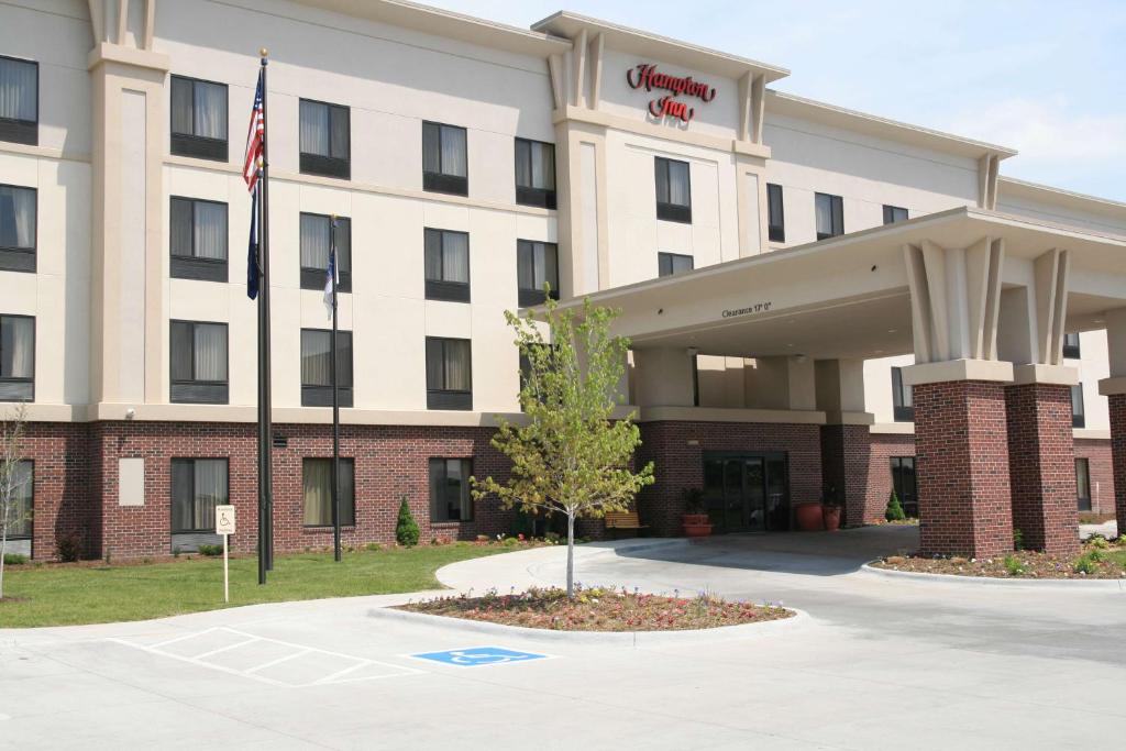 an exterior view of a hotel with an american flag at Newly Renovated Hampton Inn Omaha West Lakeside in Omaha