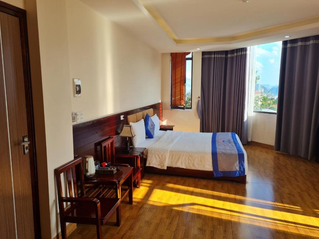 Ta Lan ThanにあるMinh Sơn HOTELのベッドとデスクが備わるホテルルームです。