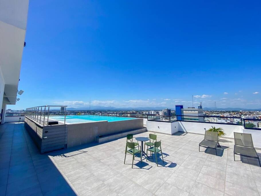 un patio avec des chaises et une piscine dans un bâtiment dans l'établissement Apartamento en bella vista, à Saint-Domingue