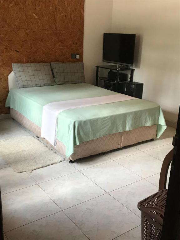 a bedroom with a bed and a tv on a floor at Saman Villa in Kadawata