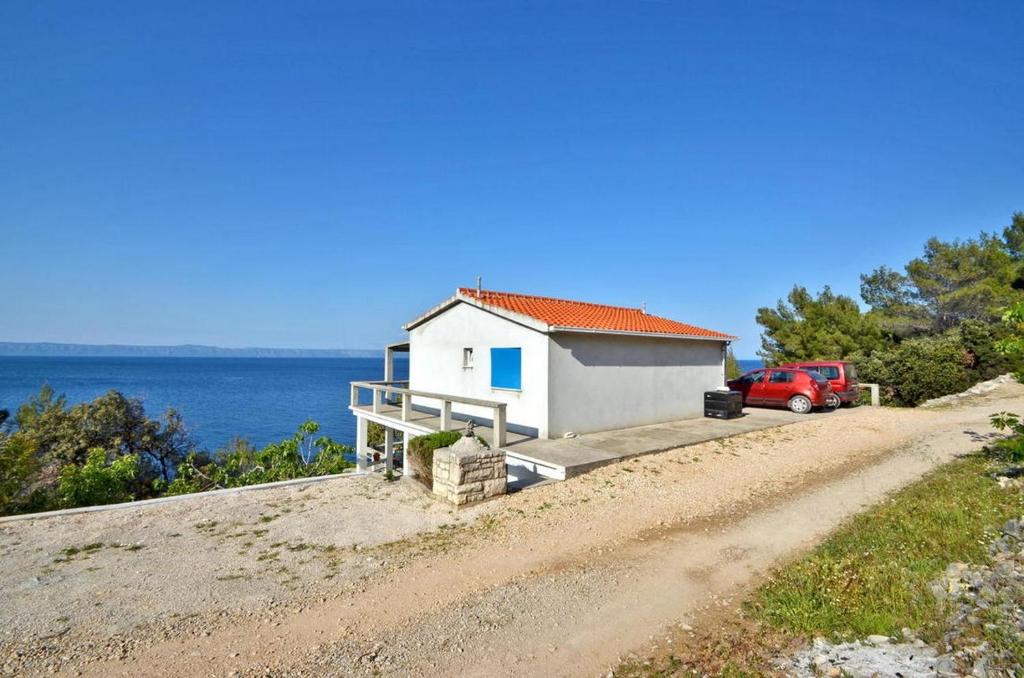 uma pequena casa branca no lado de uma estrada de terra em Seaside secluded apartments Cove Vela Borova, Korcula - 15062 em Prizba