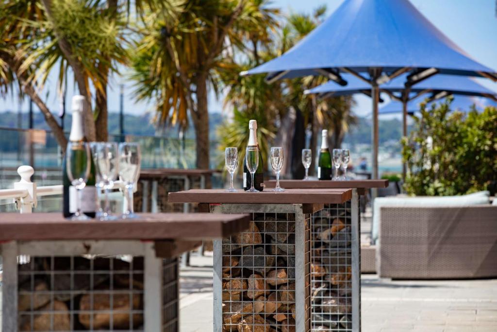 a couple of tables with glasses and a bottle of wine at Radisson Blu Waterfront Hotel, Jersey in Saint Helier Jersey
