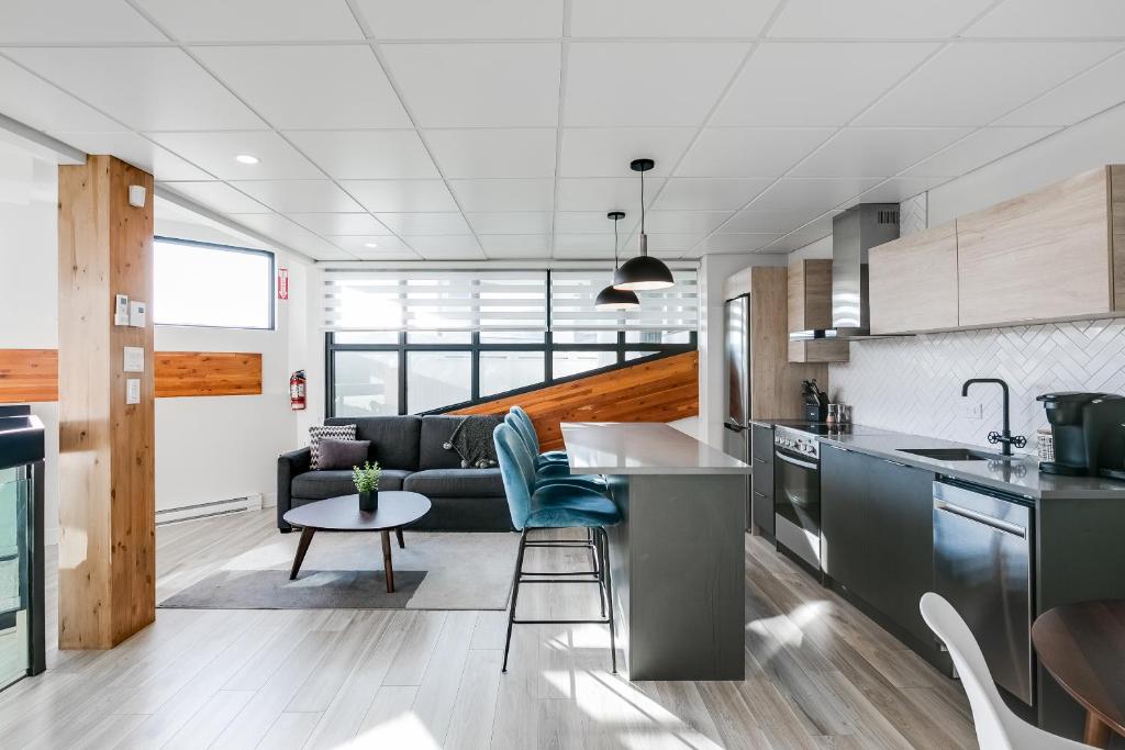 een keuken en een woonkamer met een bank bij Complexe La Voûte by KASANIA - Condo 201 in Laval